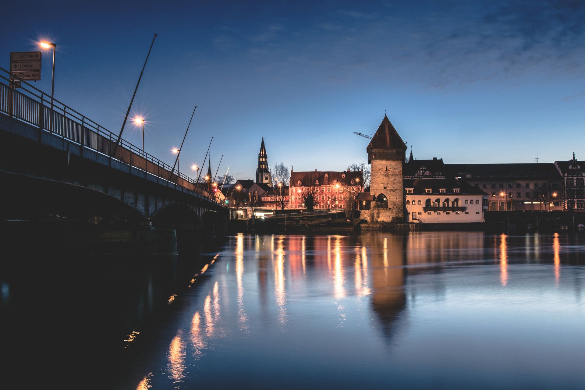 Konstanz am Bodensee zur blauen Stunde, beleuchtete Uferpromenade und ruhiges Wasser